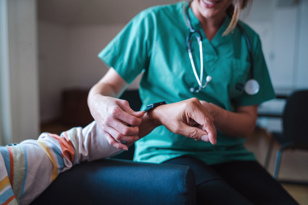 A Close up of a Nurse Showing a Patient How to Use a Smartwatch for Remote Monitoring